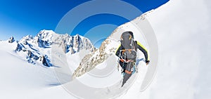 Mountaineer climbs a snowy peak. In background the glaciers and