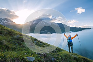 Mountaineer descending Kazbek 5054m mountain with backpack, helmets high mountaineering boots standing rising arms up with