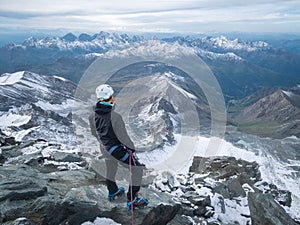 Mountaineer enjoying views on alpine landscape after reaching peak summit, Austrian Alps, Europe