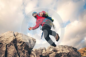 Mountaineer jumps over rocks in mountin