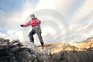 Mountaineer jumps over rocks in mountin