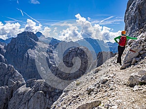 Mountaineer just below the top of the Prisojnik mountain in Julian Alps enjoying the view