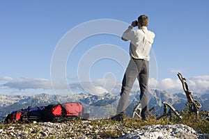 Mountaineer looking through field glasses