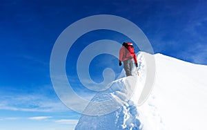 Mountaineer reach the summit of a snowy peak. Concepts: determination, courage, effort, self-realization.