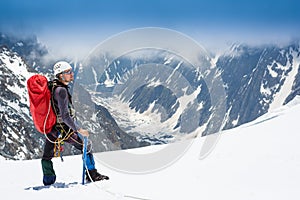 Mountaineer reaches the top of a snowy mountain