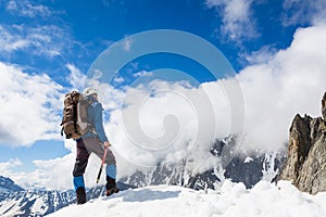 Mountaineer reaches the top of a snowy mountain