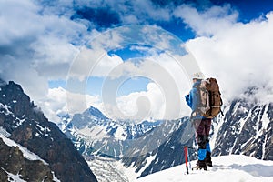 Mountaineer reaches the top of a snowy mountain photo