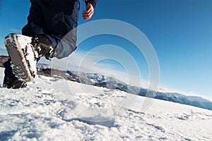 Mountaineer reaches the top of a snowy mountain.