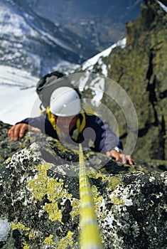 Mountaineer scaling snowy rock face photo