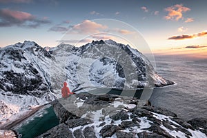 Mountaineer sightseeing on ridge with arctic ocean in Ryten mountain