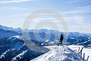 mountaineer at the summit against blue snow covered mountain layers. panoramic picture at the summit of the snowy mountain.