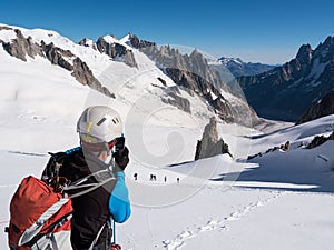 Mountaineer taking picture with a camera in the mountains.