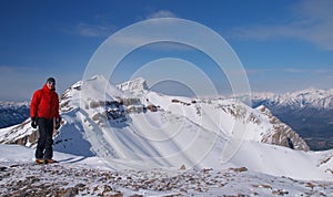 Mountaineer on top of mountain in winter