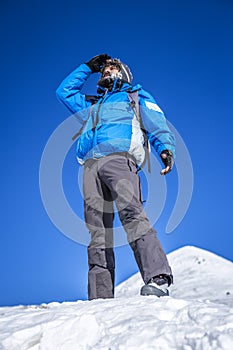 A mountaineer on the top of a snowy mountain
