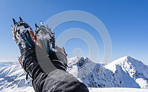 Mountaineering boots with automatic crampons on the background of mountains.
