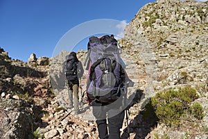 Mountaineers hiking amidst a rocky mountain landscape in Los Gigantes, Argentina