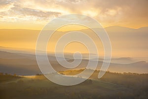 mountainous countryside landscape at foggy sunrise