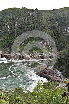 Mountainous Landscape with the beautiful beach and the famous Storms River Bridge at Tsitsikamma National Park in South Africa