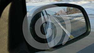 Mountainous landscape reflection in the side rearview mirror of the car. Winter season. Slow motion