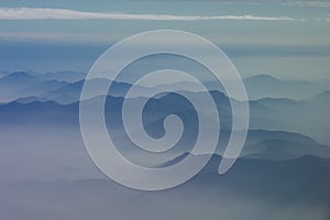 Mountainous peaks exposed through cloud photo