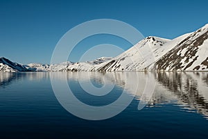 The mountainous sea coast is covered with snow