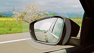 Mountains and cars and highway seen in the rear-view mirror of a car in Germany
