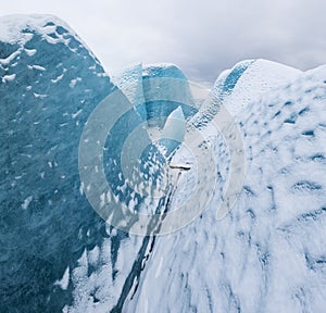 Mountains with clouds on Antarctica. Glaciers, icebergs and ice caves of Southern hemisphere. Global climate change on Earth.