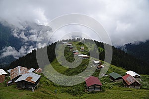 Mountains, clouds and forests with huts at The Pokut Plateau at Rize
