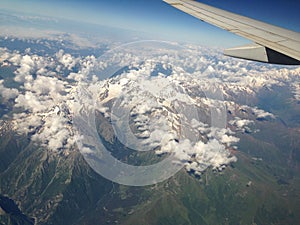 mountains and clouds from the plane window, aircraft wing element. mobile photo