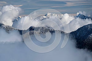 Mountains covered with fresh snow and white clouds over the peaks.