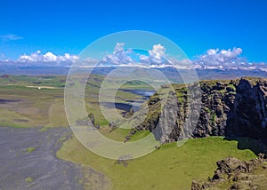 Mountains covered with green moss, black sand beach and white ocean waves on the background. Dyrholaey, South Iceland, Europe