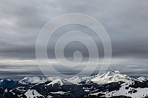 Mountains covered with snow and surrounded by clouds