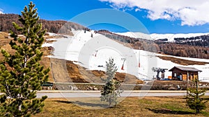 Mountains in early spring, slopes and pistes with ski lifts, Livigno village, Italy, Alps