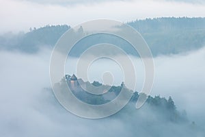 Mountains in fog at beautiful morning in autumn. Landscape with mountain valley, low clouds, forest, colorful sky , nature.