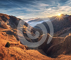 Mountains in fog at beautiful sunset in autumn. Dolomites, Italy