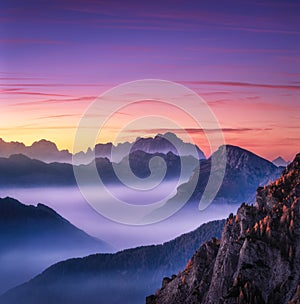 Mountains in fog at beautiful sunset in autumn in Dolomites