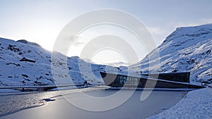 Mountains and frozen lake at Visitor centre on Trollstigen in snow in Norway in autumn