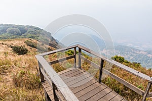 Mountains with golden grass and fog with the wooden observation deck along the way to Kew Mae Pan in Chiang Mai, Thailand
