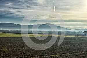 Mountains on the horizon and fog over the field