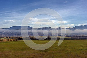 Mountains on the horizon and fog over the field