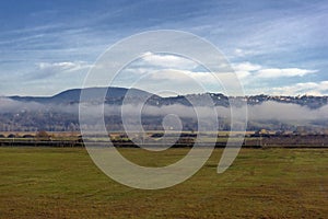 Mountains on the horizon and fog over the field