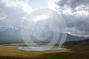 Mountains lake sun rays light clouds sky