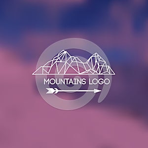 Mountains lodo on blurred background. Emblem with stylized mountain landscape photo