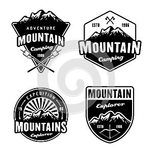 Mountains and outdoor adventure, camping and hiking set of four black vector emblems, labels, badges or logos isolated