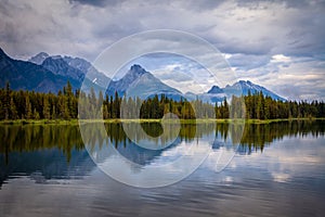 Mountains reflecting in the calm waters of Spillway Lake in Peter Lougheed Provincial Park, Alberta