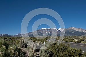 Mountains road trip. Snow mountain, blue sky and asphalt road