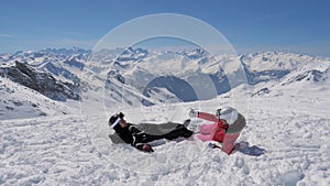 In the mountains ski resort a lovely couple of skiers playing snowballs