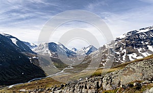 Mountains with snow and a valley with river in jotunheimen national park