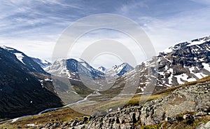 Mountains with snow and a valley with river in jotunheimen national park photo
