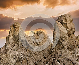 Mountains, in the sunset light, embossed rocks. A lone tree on the rocks. Photo.